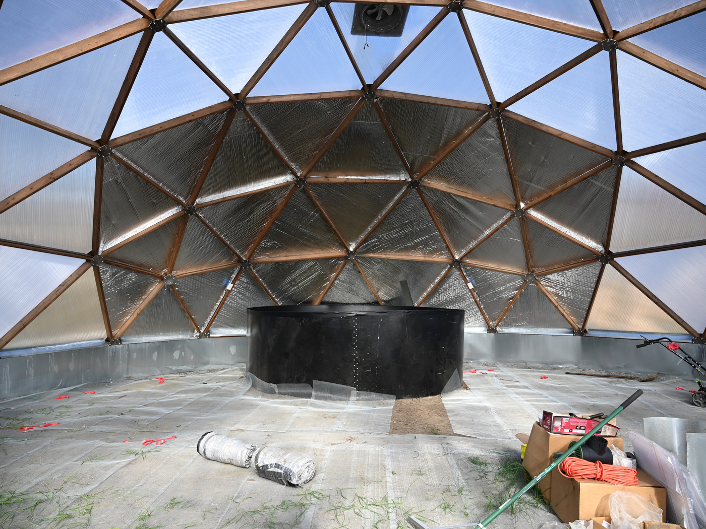 Inside the geodesic grow dome during construction, showing the timber frame